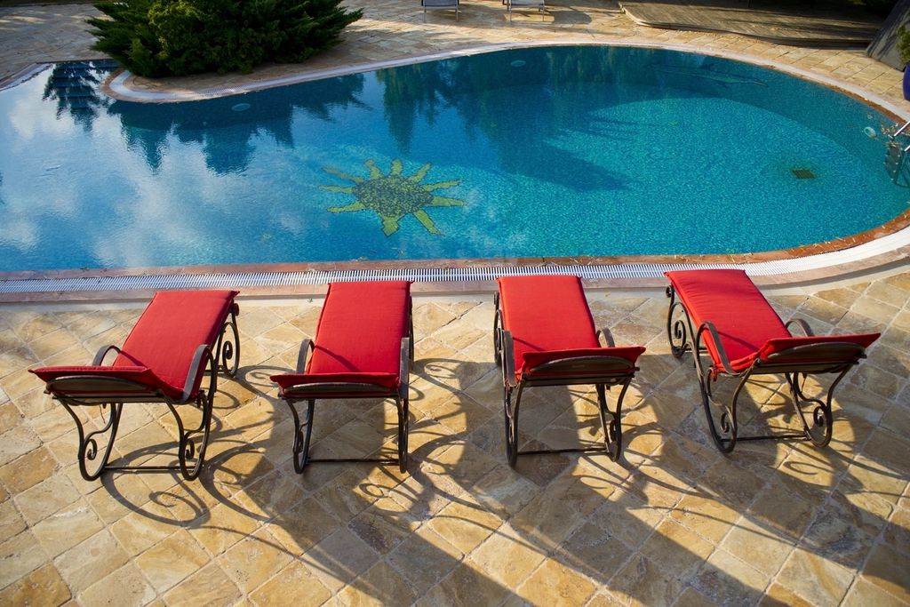 The outdoor swimming pool with loungers alongside